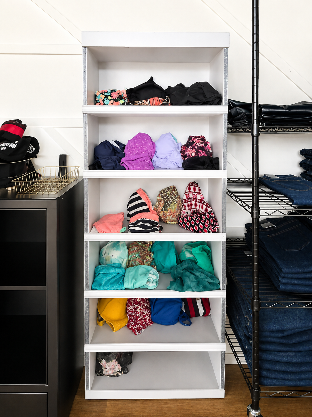 Folded clothing arranged by color on shelving