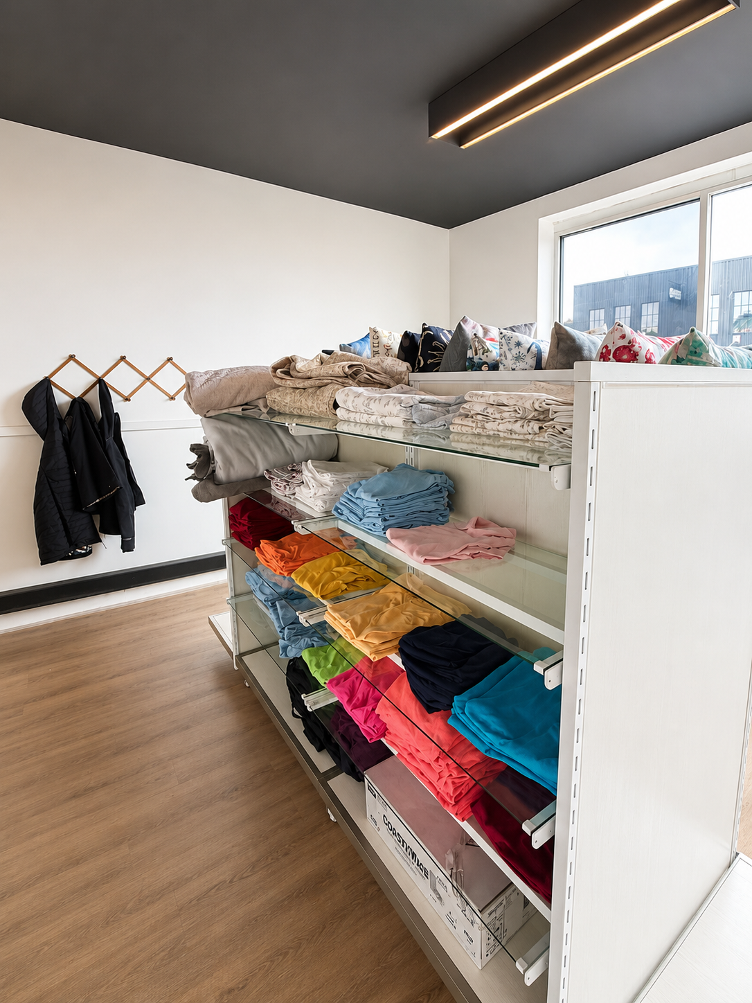 Colorful folded clothing and handmade pillows inside Brady's Closet